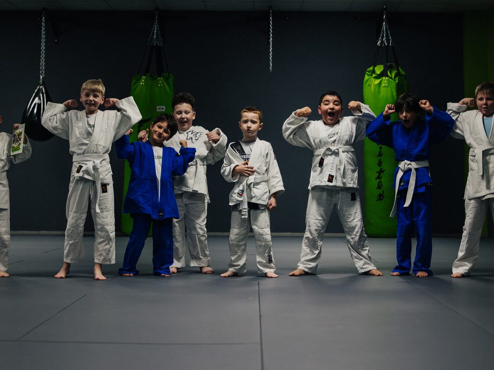 Kindergruppe im Gi jubelt nach dem Training
