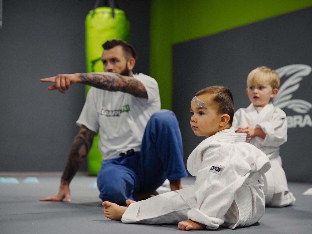 Trainer erklärt Kindern eine Übung